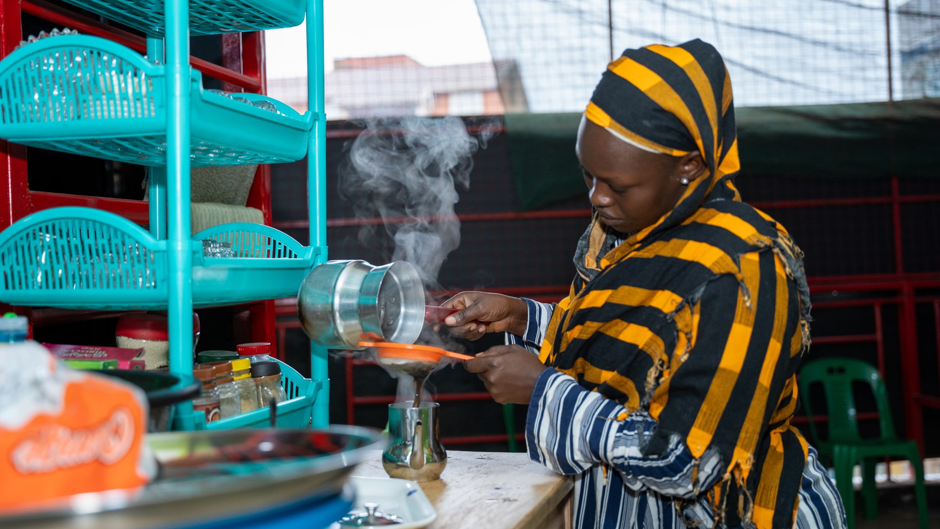 Mariya Koche prepares tea in her cafeteria, a member Greenlight savings group facilitated by ReBUiLD to strengthen its system for linkage to formal financial service providers